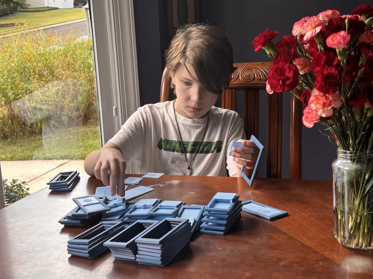 A child sorting and clipping DoDone frames together at a table